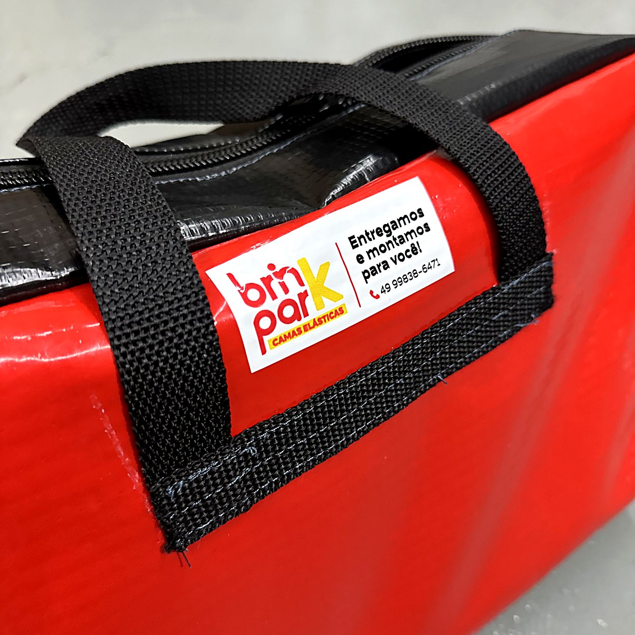 Detalhe da alça e da etiqueta BrinkPark na bolsa de molas